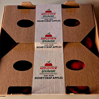 Cardboard box with Appleview Orchards honeycrisp apples label on a neutral background