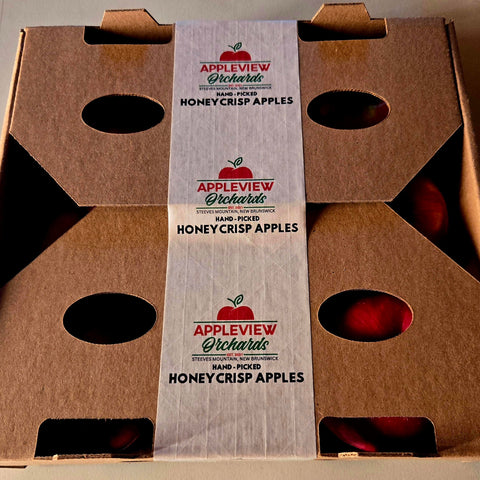 Cardboard box with Appleview Orchards honeycrisp apples label on a neutral background