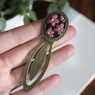 a hand holding a Floral embroidered bookmark