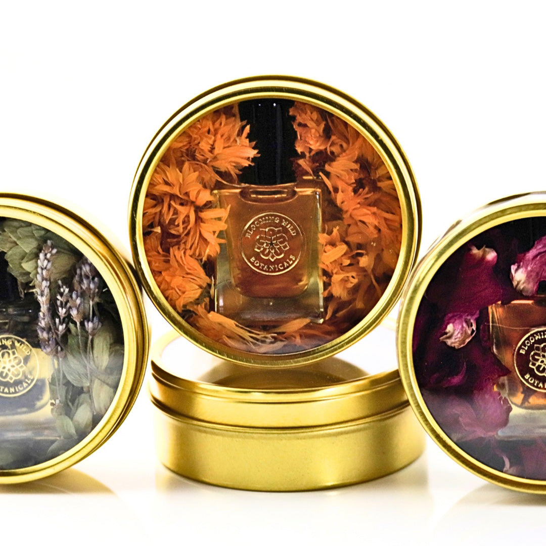 a group of round containers with a bottle of Eunoia Aromatherapy Body & Perfume Oil W/ Tin inside