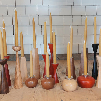 a group of candles in wooden holders from Brent Rourke