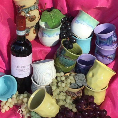 a group of Wine Tumblers from Greig Pottery and a bottle of wine