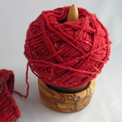 A ball of red yarn on a wooden stand from Moosehill Woodworks 
